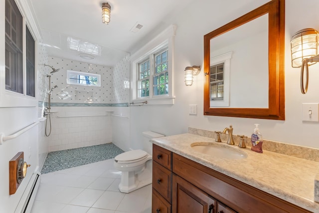 full bath with a tile shower, vanity, tile patterned floors, a baseboard heating unit, and toilet