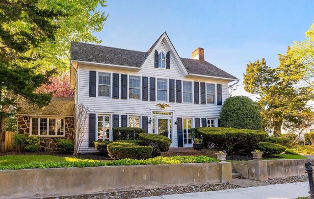 colonial inspired home featuring a chimney