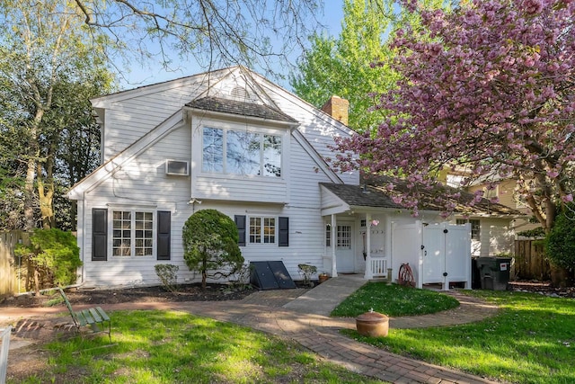 view of front of house with fence, a chimney, and a front yard
