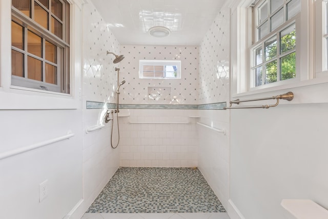 full bathroom featuring tiled shower and tile patterned flooring