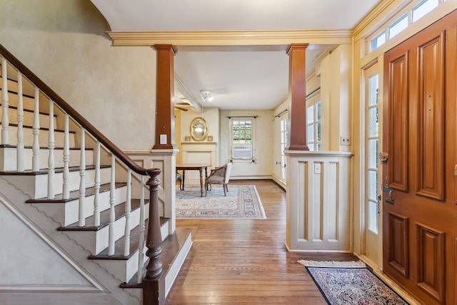 entrance foyer featuring stairs, decorative columns, wood finished floors, and cooling unit