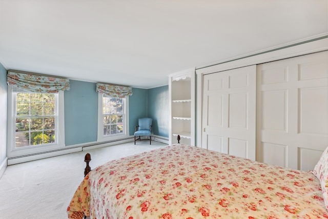 carpeted bedroom featuring a closet and a baseboard heating unit