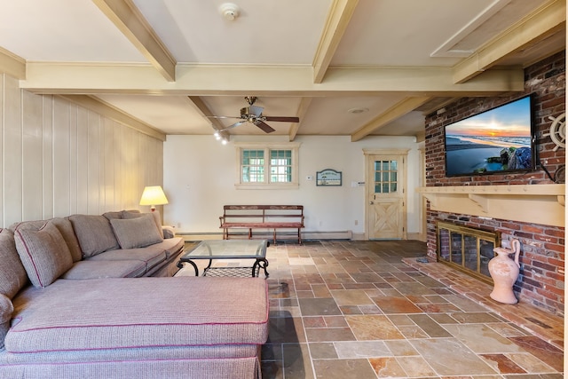 living room with a fireplace, a ceiling fan, baseboards, beamed ceiling, and stone tile flooring