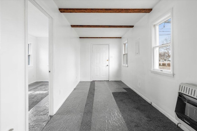 hallway featuring plenty of natural light, beam ceiling, carpet, and heating unit