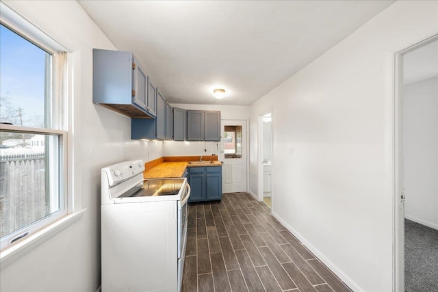 kitchen featuring white electric range, dark hardwood / wood-style floors, sink, and plenty of natural light