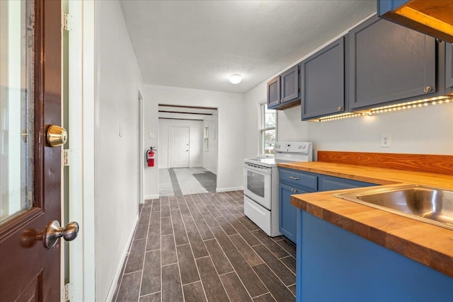 kitchen featuring electric stove, butcher block countertops, sink, dark wood-type flooring, and blue cabinets