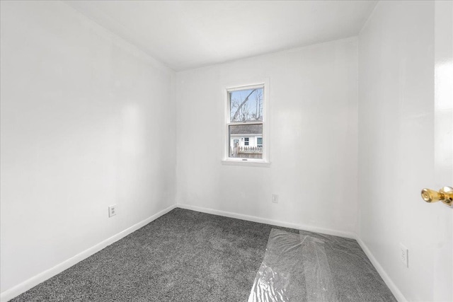 spare room featuring dark colored carpet