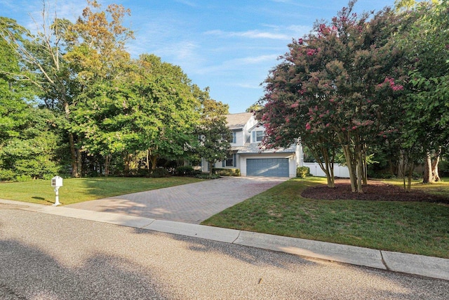 obstructed view of property featuring a garage and a front lawn