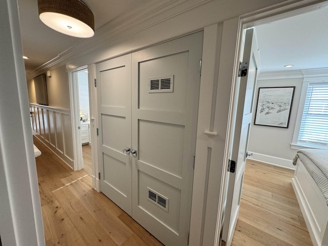 corridor featuring light hardwood / wood-style flooring and crown molding