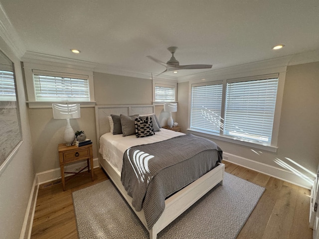 bedroom with ceiling fan, crown molding, and hardwood / wood-style flooring