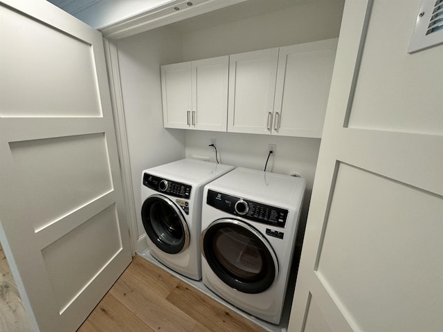 washroom featuring cabinets, independent washer and dryer, and light wood-type flooring