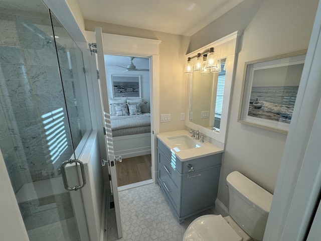 bathroom with ceiling fan, toilet, a shower with door, and vanity