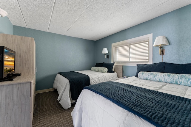 carpeted bedroom with a textured wall and baseboards