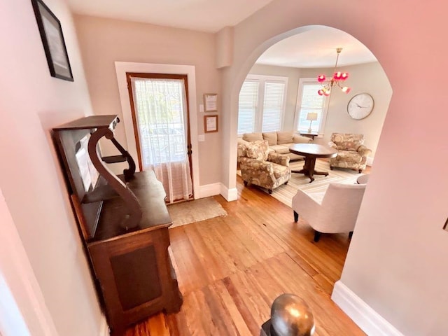 foyer entrance with light hardwood / wood-style floors and a notable chandelier