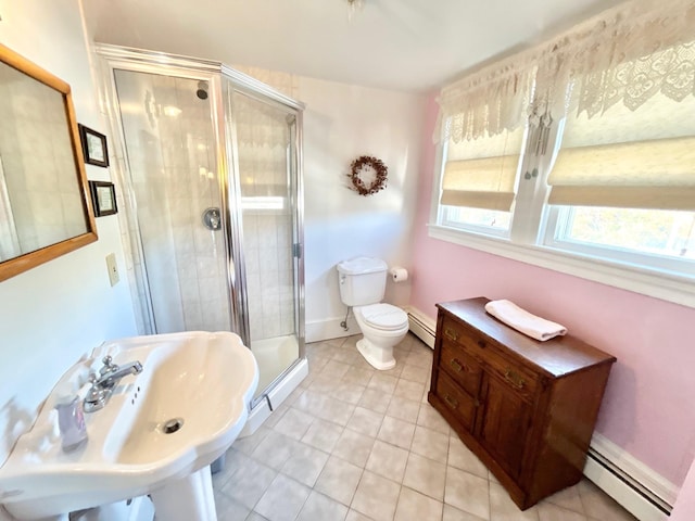 bathroom featuring tile patterned floors, sink, toilet, baseboard heating, and a shower with shower door