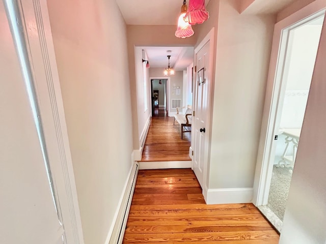 hall featuring light wood-type flooring and a baseboard heating unit