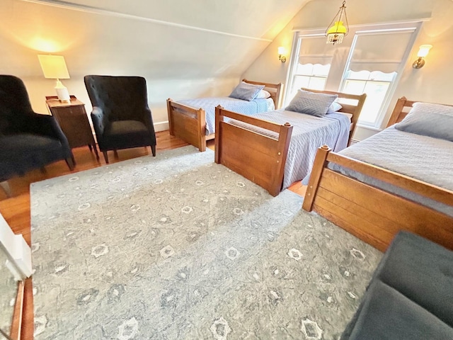 bedroom with light hardwood / wood-style floors and vaulted ceiling