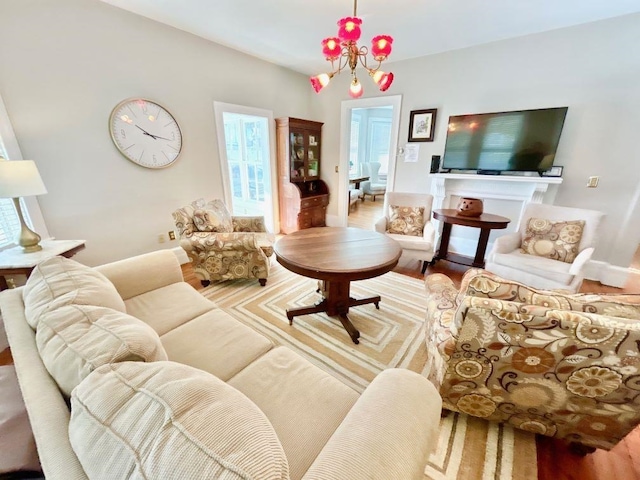 living room with a wealth of natural light, wood-type flooring, and an inviting chandelier