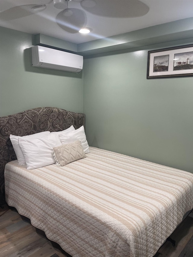 bedroom with ceiling fan, dark wood-type flooring, and a wall mounted air conditioner