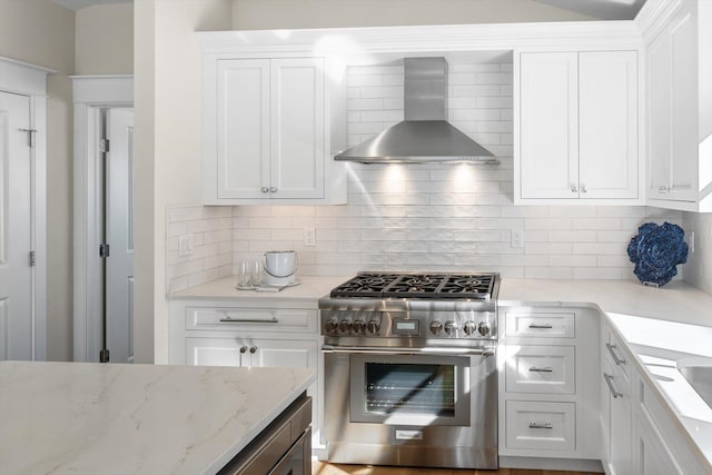 10700 3rd Ave S, Unit South, Stone Harbor, NJ 08247 - kitchen with backsplash, light stone counters, stainless steel range, white cabinets, and wall chimney exhaust hood