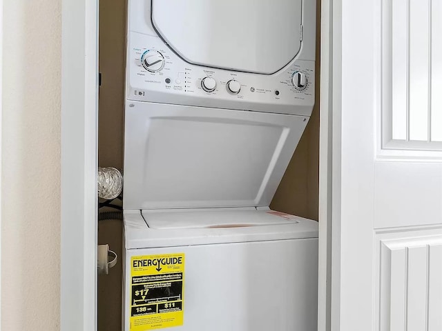 clothes washing area with stacked washer and dryer