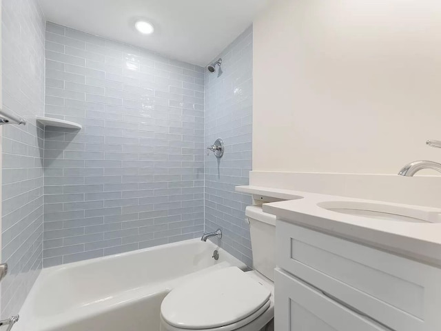 full bathroom featuring vanity, tiled shower / bath, and toilet