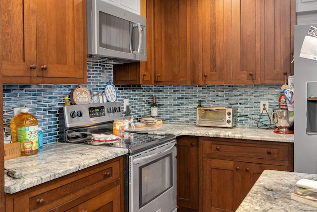 716 Dias Creek Rd, Cape May Court House, NJ 08210 - kitchen featuring appliances with stainless steel finishes, backsplash, brown cabinetry, and light stone counters