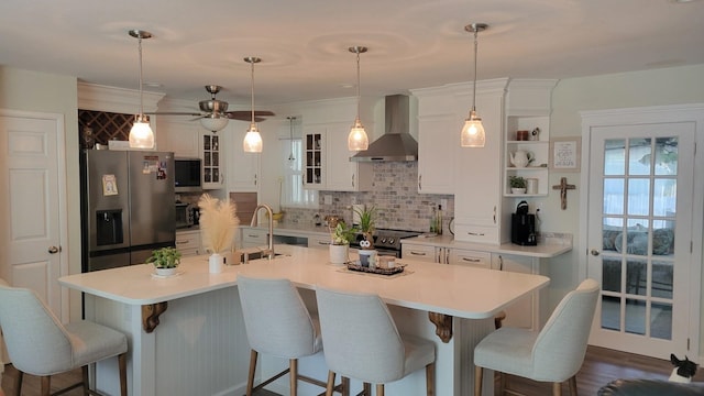 113 Heidi Ave, North Cape May, NJ 08204 - kitchen with wall chimney exhaust hood, stainless steel fridge, a sink, decorative backsplash, and a center island with sink