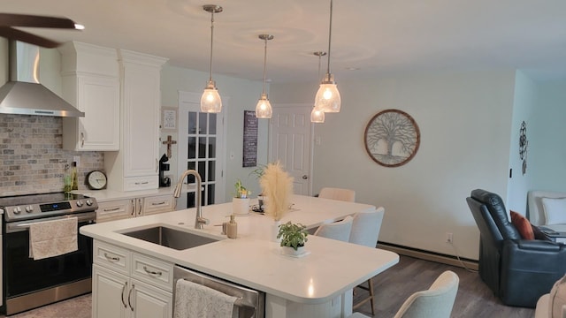 113 Heidi Ave, North Cape May, NJ 08204 - kitchen featuring stainless steel appliances, a sink, wall chimney range hood, a baseboard radiator, and decorative backsplash
