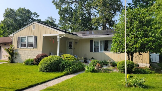 113 Heidi Ave, North Cape May, NJ 08204 - view of front of property featuring a front lawn, solar panels, and brick siding
