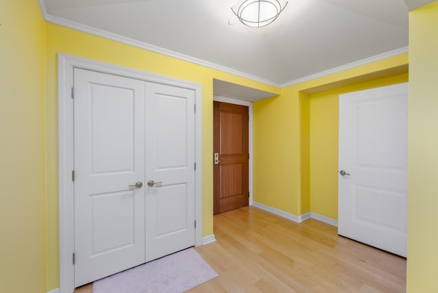 unfurnished bedroom featuring light hardwood / wood-style floors, a closet, and crown molding