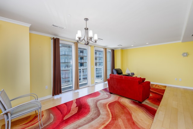 living room with light hardwood / wood-style floors, a chandelier, and ornamental molding