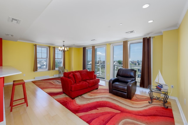 living room with a chandelier, crown molding, and light hardwood / wood-style floors