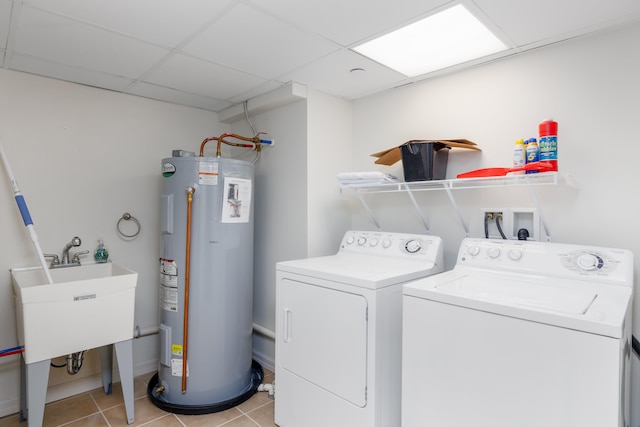 washroom featuring sink, electric water heater, separate washer and dryer, and light tile patterned flooring