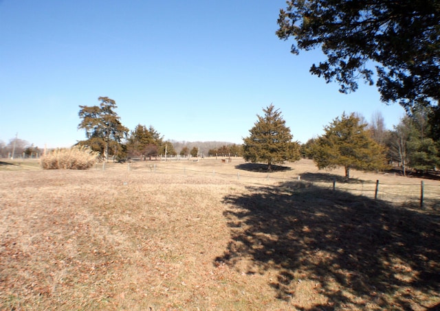 view of yard with a rural view and fence