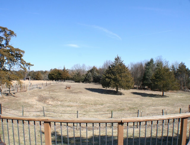 view of yard with fence and a rural view