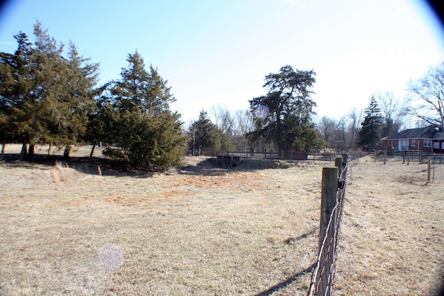 view of yard with a rural view and fence