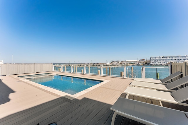 view of pool featuring a fenced in pool, a boat dock, and a water view