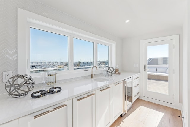 370 83rd St E, Unit East, Stone Harbor, NJ 08247 - kitchen with wine cooler, white cabinets, light wood-style floors, light countertops, and recessed lighting