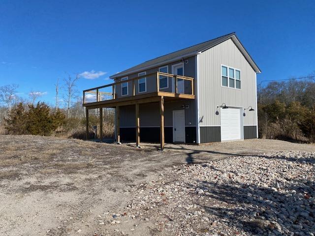 back of house with a wooden deck and a garage