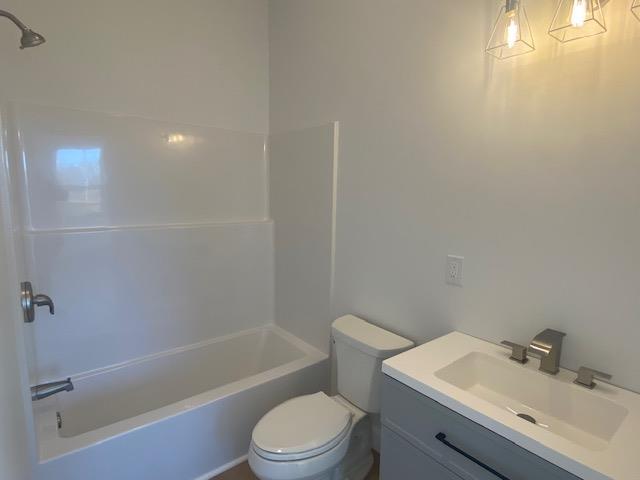 full bathroom featuring vanity, shower / tub combination, and toilet