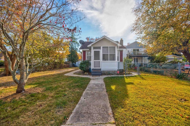 bungalow with a sunroom and a front lawn