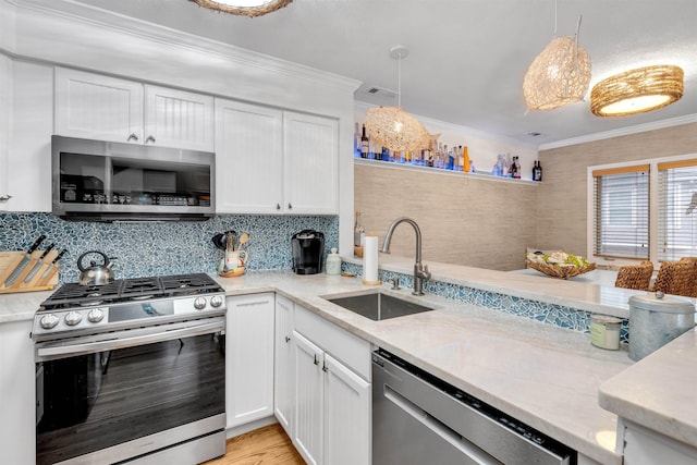 kitchen with white cabinetry, sink, hanging light fixtures, crown molding, and appliances with stainless steel finishes