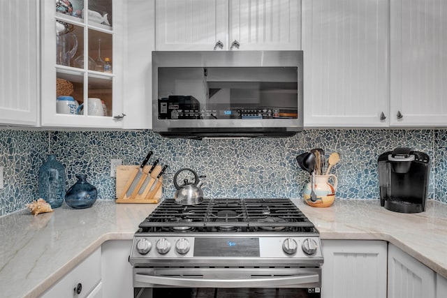 301 E S Station Ave Unit 126, Lower Township, NJ 08260 - kitchen featuring decorative backsplash, light stone counters, white cabinetry, and appliances with stainless steel finishes