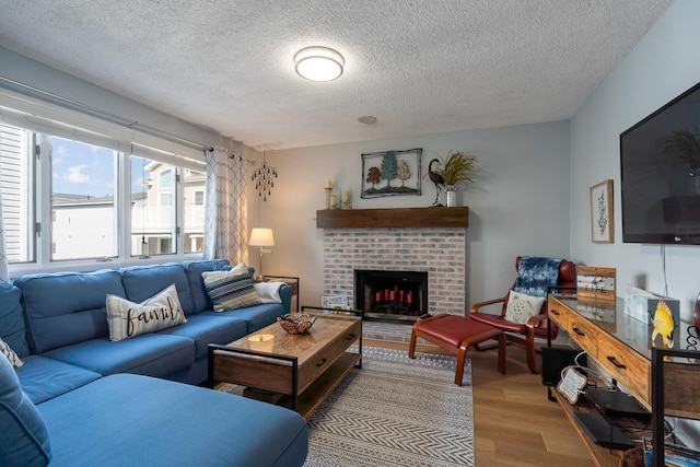 living room featuring a fireplace, a textured ceiling, and light wood-type flooring