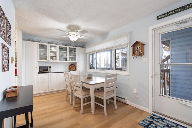 dining area with ceiling fan, a textured ceiling, and light wood-type flooring