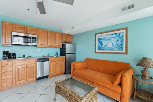 kitchen with ceiling fan, sink, light tile patterned flooring, and appliances with stainless steel finishes