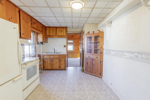 kitchen with a wealth of natural light, stove, white fridge, and sink