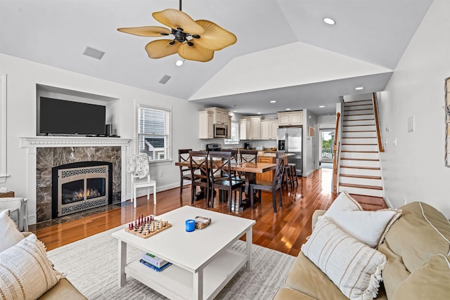 364 41st St E, Unit East, Avalon, NJ 08202 - living room featuring a ceiling fan, vaulted ceiling, wood finished floors, stairway, and a tile fireplace