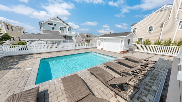 view of swimming pool with a fenced in pool, a residential view, a fenced backyard, and an outbuilding